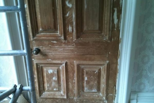 door with paint stripped off to reveal natural wood finish underneath