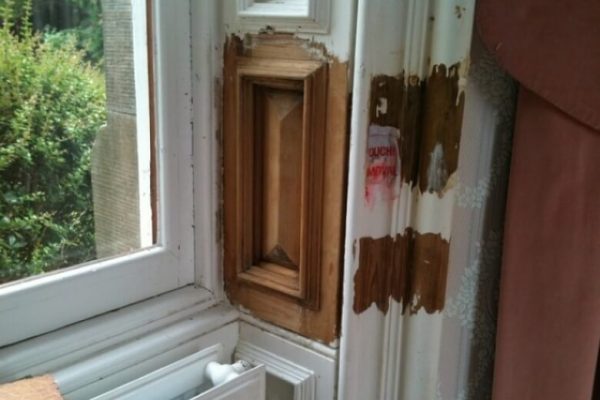 close up of a window surround that has had the paint stripped off to reveal the natural wood finish underneath