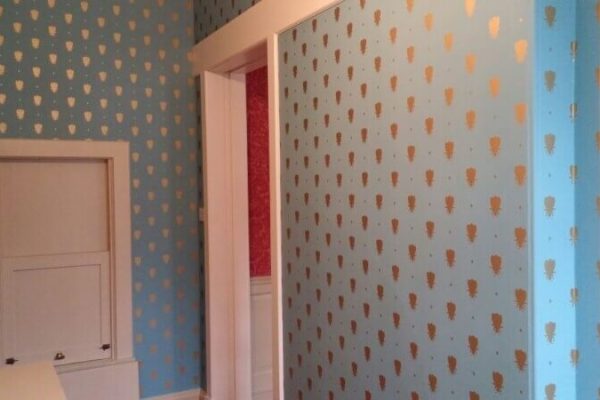 light blue wallpaper, with gold pattern repeated across