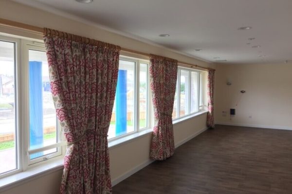 curtains in a newly painted large room with hard wood floor
