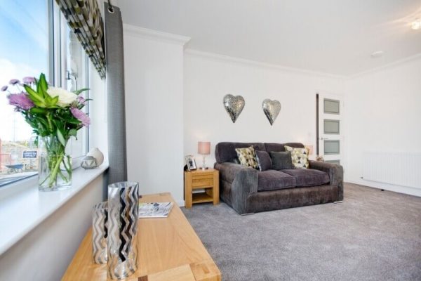 newly decorated room with new couch and window overlooking a city or town